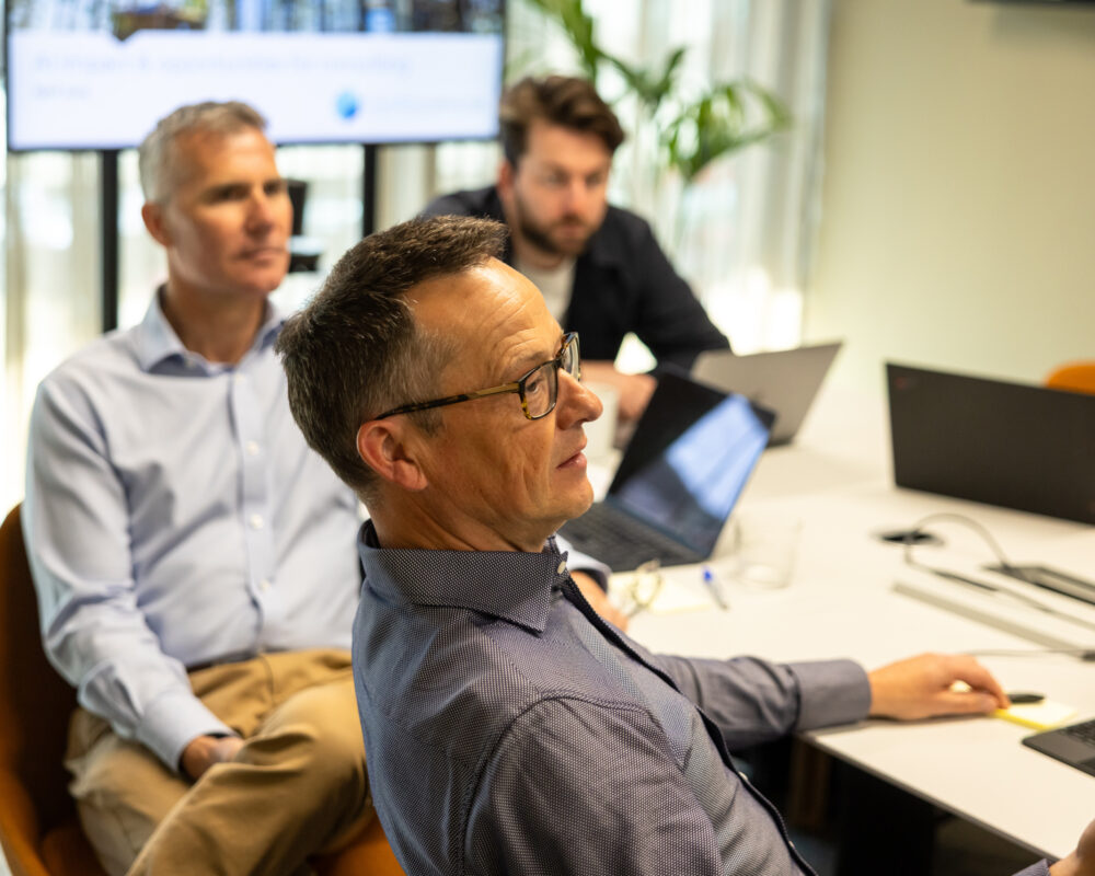 Man in office focused on computer screen, working in a modern workspace